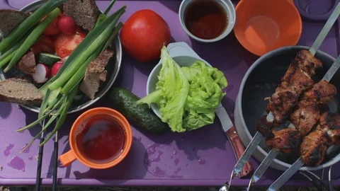 Top view of young people having dinner outdoor. Grilled meat, fresh vegetables Stock Footage 80012071