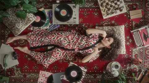 Top View of Young Woman Lying on Vintage Rug and Dancing to Vinyl Music Stock Footage 339852393