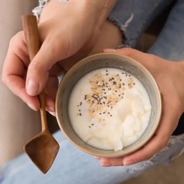Top view on young woman's hands holding bowl with homemade organic vanilla yo Stock Photos