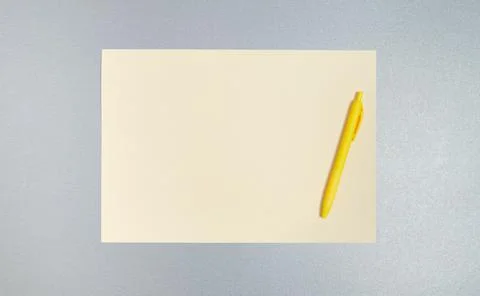 Top view,copy space, flat lay of yellow pen and sheet of paper on a gray surf Stock Photos