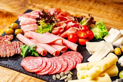 Top view.Various types of meat and sausages on wooden table.Assorted meats and Stock Photos
