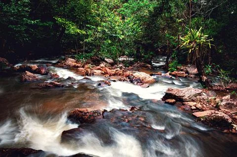 From the top of the waterfall, the river flows between the rocks. Stock Photos