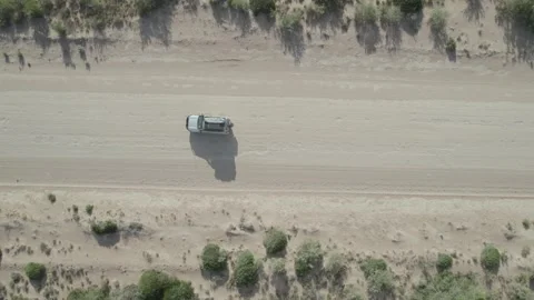 Topdown aerial drone view of an adventure truck driving on a sandy track 库存影片 341667498
