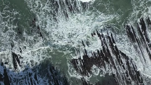 Topdown aerial view of ocean waves crashing on Sakoneta beach rocks in slow 库存影片 334256740