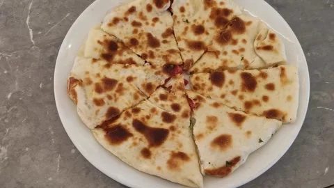 Topdown dolly pan of sliced quesadilla on white plate on marble countertop .. Stock Footage 329871104