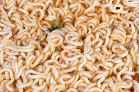 Topdown raw instant noodles disk on pale background, minimalist composition emph Stock Photos