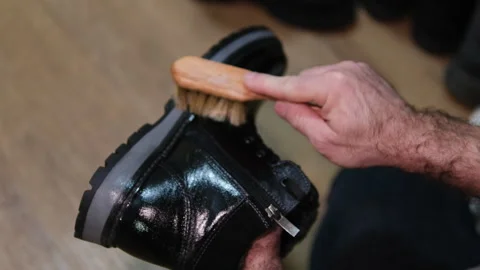 Topic care and brushing warm shoes expertly with small brush in workshop Stock Footage 302673940