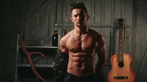 Topless guy undressed shirt. Young sexy man with muscular body takes off his Stock Footage 291954413