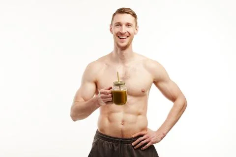 Topless man stands in front of the camera with a glass cup. Foto stock