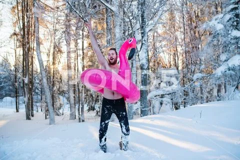 Topless young man outdoors in snow in winter forest, having fun. Stock Photos