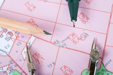 Topographic map of district with a measuring instrument and pencils Stock Photos