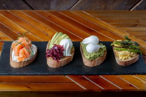 Topped Bread with different toppings salmon cream cheese, eggs avocado eggs Fotos Stock