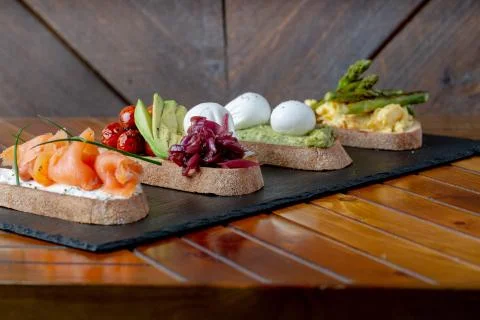 Topped Bread with different toppings salmon cream cheese, eggs avocado eggs Stock Photos