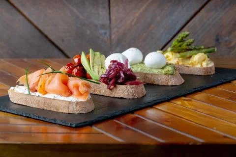 Topped Bread with different toppings salmon cream cheese, eggs avocado eggs Stock Photos