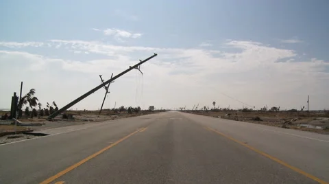 Toppled power pole with broken lines leaning over highway  in aftermath of a Vídeo Stock 59548332