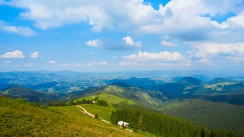The tops of high mountain trees and a blue sky with clouds. Stock Footage 123489262