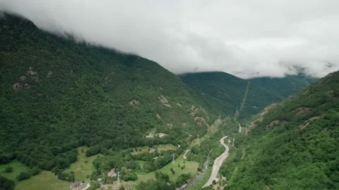 The tops of the mountains in the clouds. Asphalt road. Stock Footage 159597360