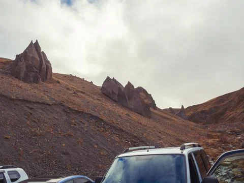 On the tops of the mountains under the cloudy sky are huge sharp stone Stock Photos