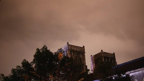 Tops of St. Josephs Cathedral peeking from behind trees at night time in hanoi Stock Footage 147366830
