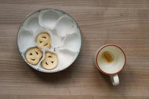 Topview of empty coffee cup and cookie tin on table Stock Photos