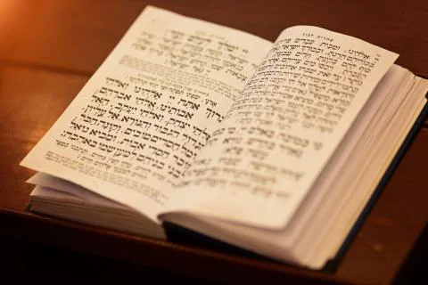 Torah Scroll is the holiest book within Judaism, Jewish praying book on table Stock Photos