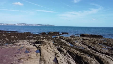 Torbay, South Devon, England: Drone View: Isolated man, rock formations and sea Stock Footage 218853013