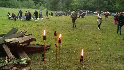 Torch flame and people prepare for annual midsummer day celebration Stock Footage 104866313