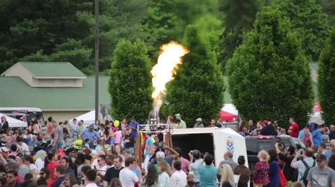 Torch flame in the middle of a large crowd at a Hot Air Balloon Festival Stock Footage 64821936