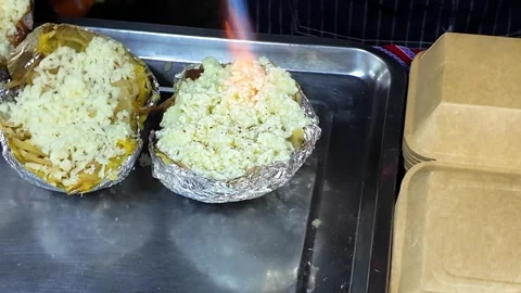 Torching Cheese on Stuffed Baked Potato at Street Food Stall Stock Footage 337421338