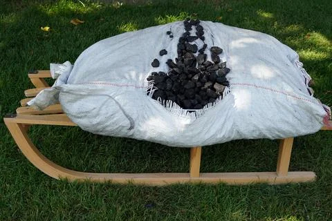 Torn bag of coal Stock Photos