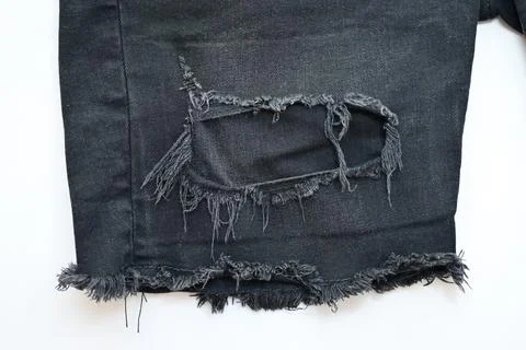Torn black danim texture on white background, textile of jeans fashion for .. Fotos Stock