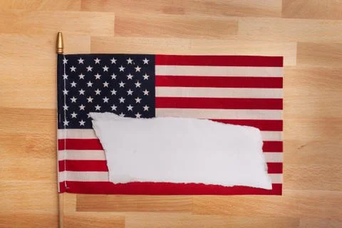 Torn blank white sheet of paper sitting on an American flag add text Stock Photos