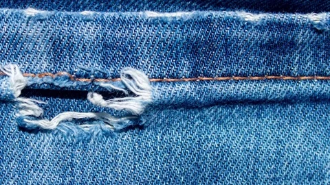 Torn Blue Denim Fabric Texture Close Up, Distressed Jean Material with Frayed Stock Footage 333507815