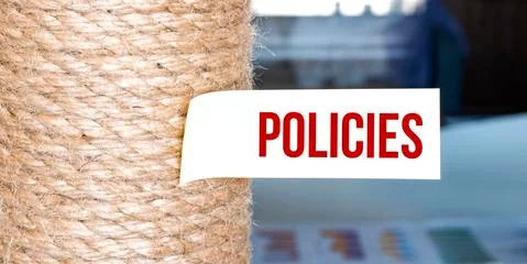 Torn brown paper on white surface with text POLICIES Stock Photos