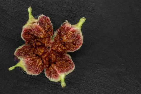 Torn common fig fruit on black stone background Stock Photos