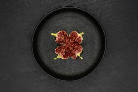 Torn common fig fruit in iron cast plate Stock Photos