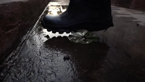 Torn leather boot steps on the puddle after rain Stock Footage 146466287