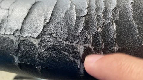 Torn old black leather office chair close up view. Broken, finger inspecting Stock Footage 250063459