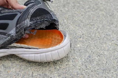 Torn old black shoe on the back of the heel. Foto stock