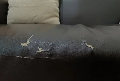 Torn old leather black sofa. old leather seat lack from long service life Foto stock