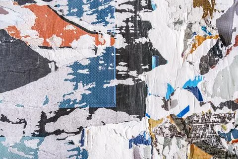 Torn paper collage background on an old poster on a street wall. Texture and Stock Photos