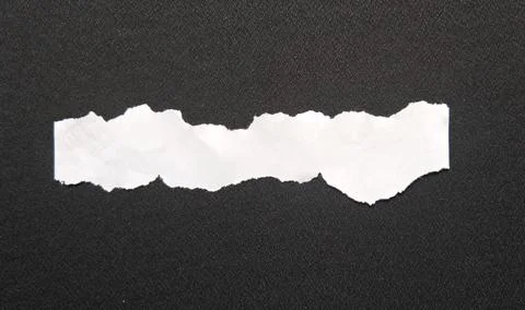 Torn Paper Strip on Dark Surface Фото