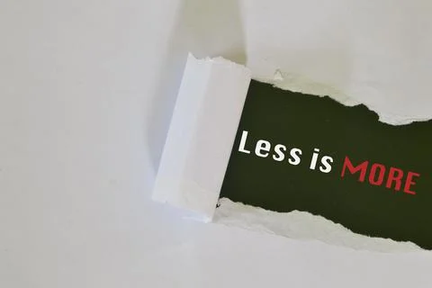 Torn paper written with text LESS IS MORE. Stock Photos