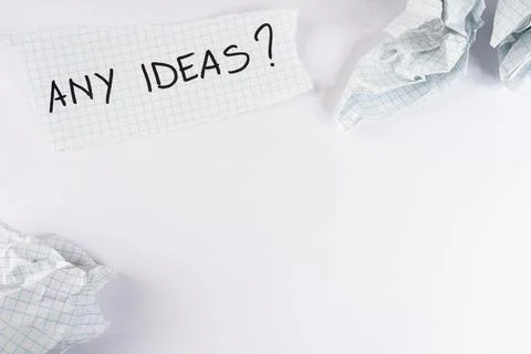 Torn piece of graph paper displaying the handwritten question any ideas sur.. Fotos de archivo