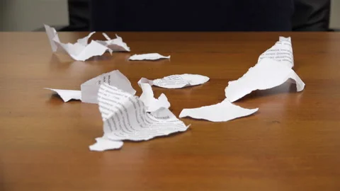 Torn pieces of a document fall on top with scraps on the table Video stock 99942187