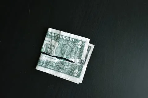 Torn ripped devalued one dollar bank note on a black background. close-up of  Stock Photos