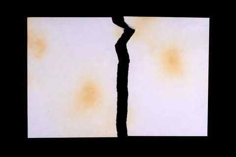 Torn sheet of yellowed old paper with multiple damage from fire and time, iso Stock Photos