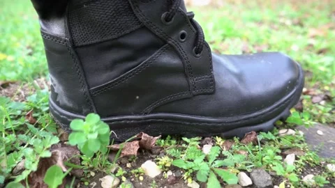 Torn soldiers boot steps down on the ground Video stock 146466361