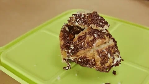 Torn sweet bread roll with chocolate sprinkles and white buttercream on a g.. Stock Footage 323571710
