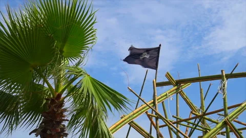 Torn tattered pirate flag waves in the wind tied to rigging on tall ship Video stock 94137016